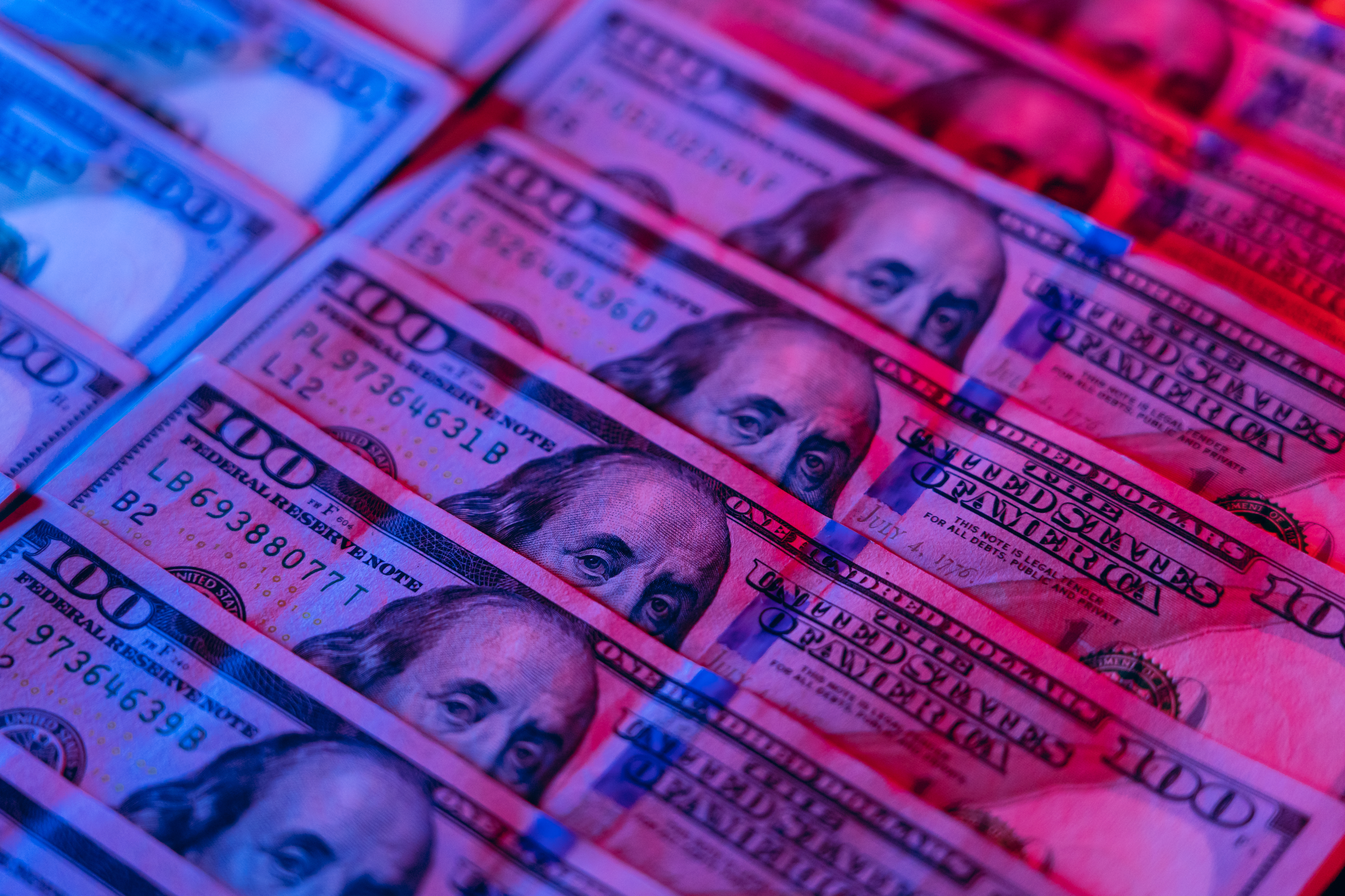 Money background. Dollars lit by blue and red.